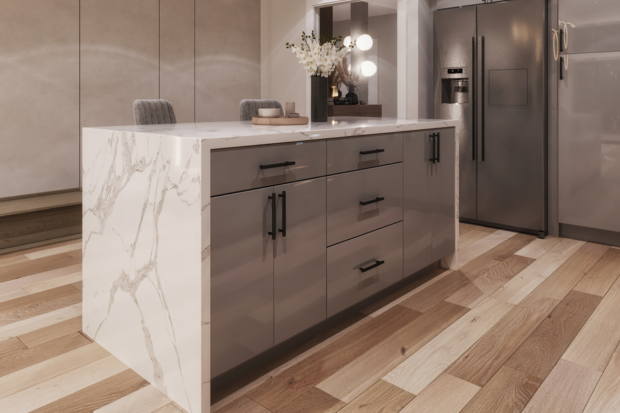 A modern kitchen island with a white marble-patterned side panel and a white countertop, paired with glossy gray cabinets and black handles. The island is set in a contemporary kitchen with light wood floors, stainless steel appliances, and a vase of flowers on top.